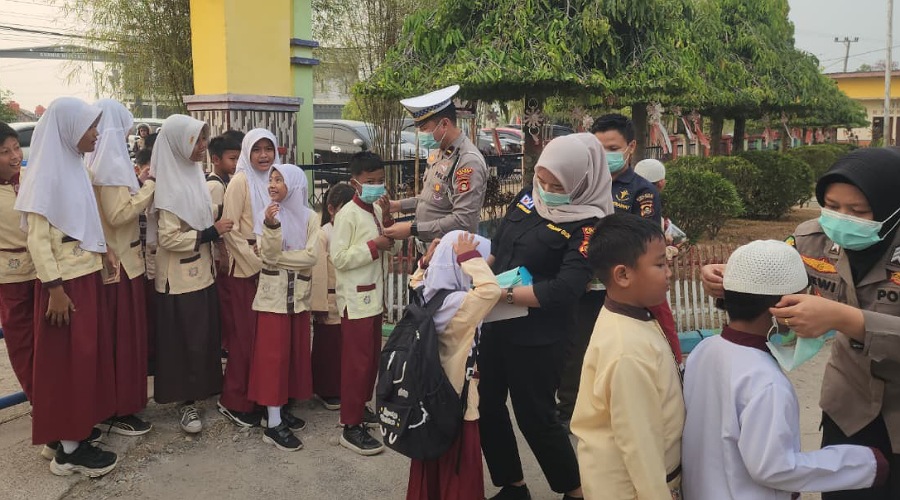 Antisipasi Debu dan Asap Karhutla, Polres OKU Timur Bagikan Masker ke Siswa SD
